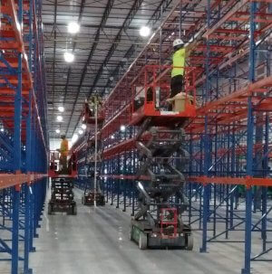 Warehouse label installation crew on scissor lifts
